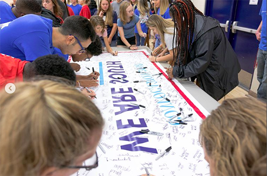 Students signing a banner at Convocation